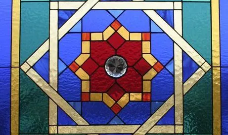 Geometric stained glass panel with an eight-point star in red and gold